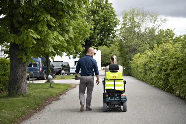 En kvinde faar testet sine koerefaerdigheder på el-scooter af en ansat i HandicapBilistCentret.