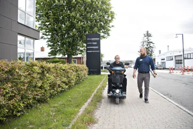 En mand faar testet sine evner til at betjene en elscooter og faerdes sikkert i trafikken af en koerelaerer fra HandicapBilistCentret