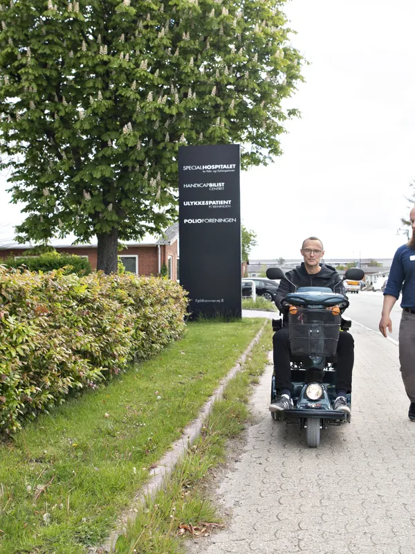 En mand faar testet sine evner til at betjene en elscooter og faerdes sikkert i trafikken af en koerelaerer fra HandicapBilistCentret