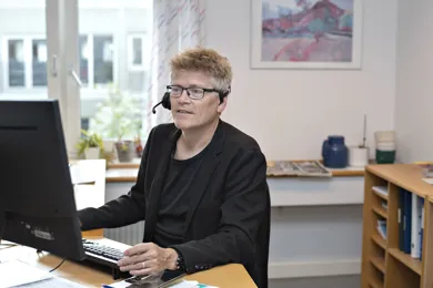 En medarbejder fra HandicapBilistCentret sidder klar til at svare paa spørgsmaal.