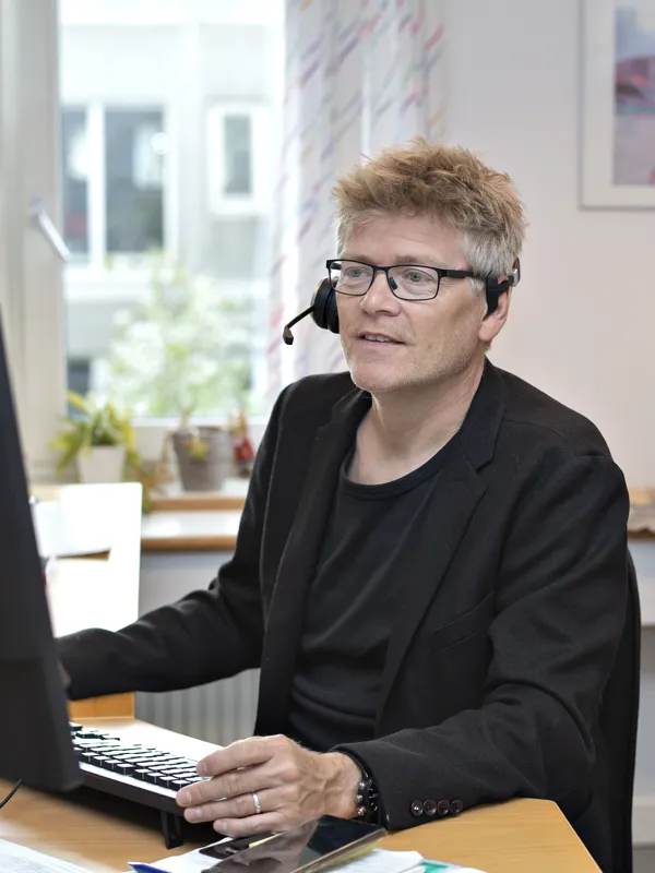 En medarbejder fra HandicapBilistCentret sidder klar til at svare paa spørgsmaal.